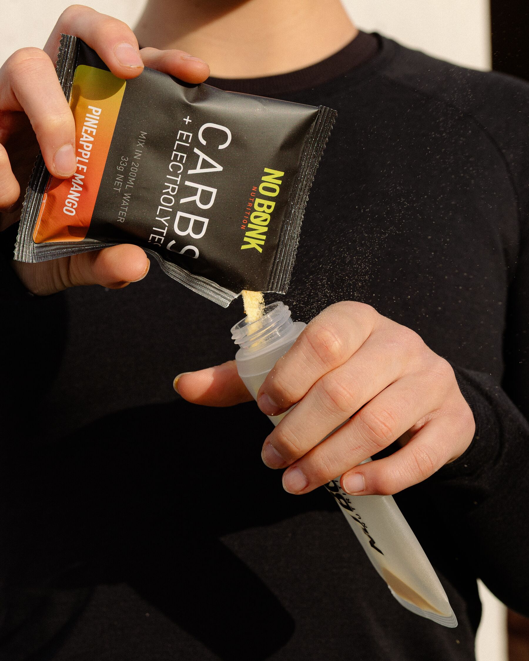 A NOBONK Pineapple Mango sachet being squeezed into a 200ml soft flask