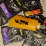 NOBONK Grape and Pineapple Mango sachets scattered around a filled soft flask
